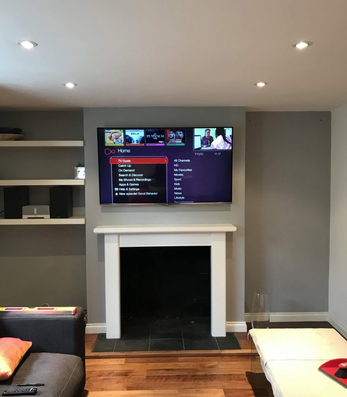 55 inch LG TV wall mounted above a fireplace in a living room.